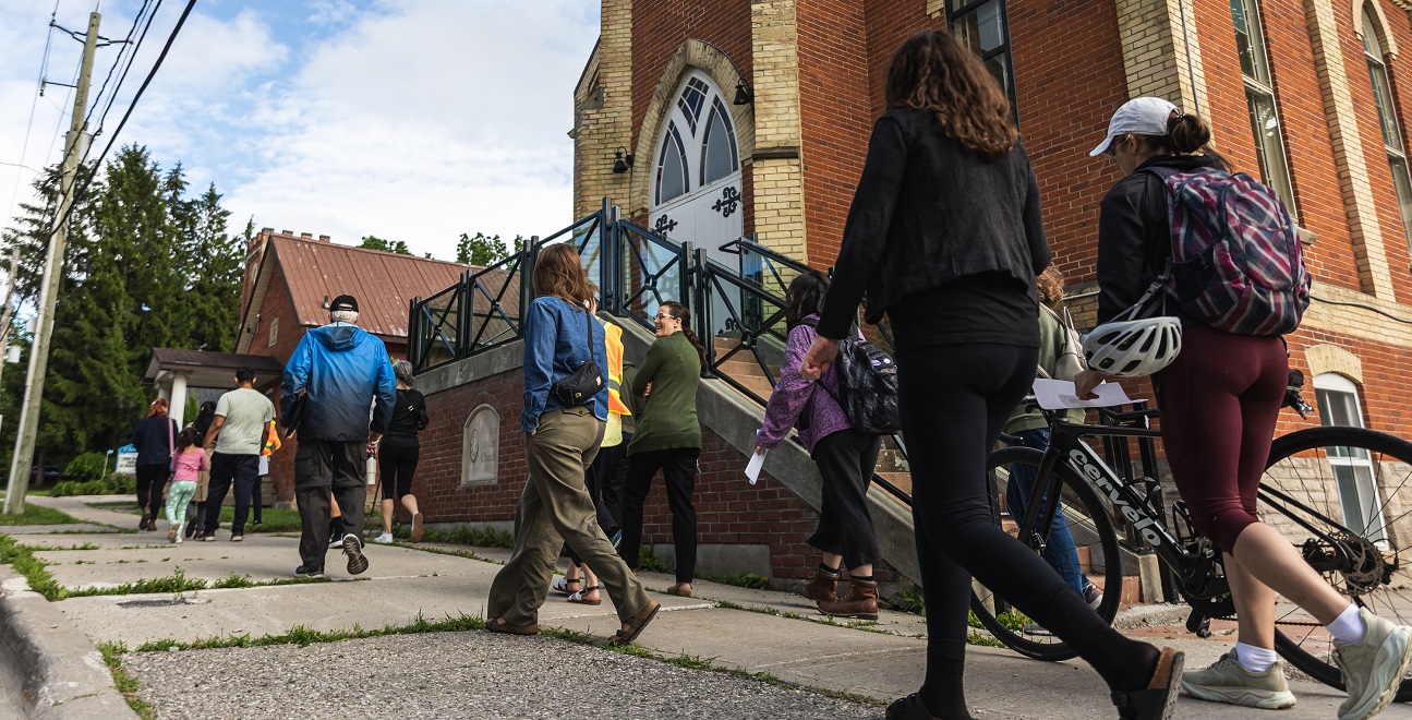community members pass Bolton United Church on a neigbhbourhood tour as they celebrate 10 years of the West Bolton SNAP program