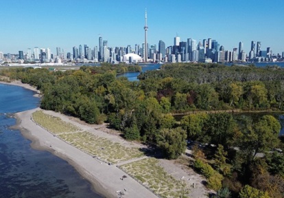 an aerial view of Tommy Thompson Park with the Toronto skyline in the background