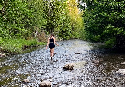a woman explores Duffins Creek at Claremont Nature Centre