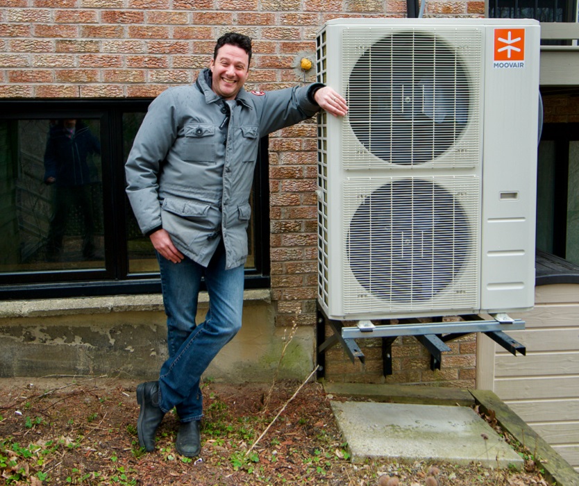 A Peel homeowner poses with an energy efficient heat pump installed on his property