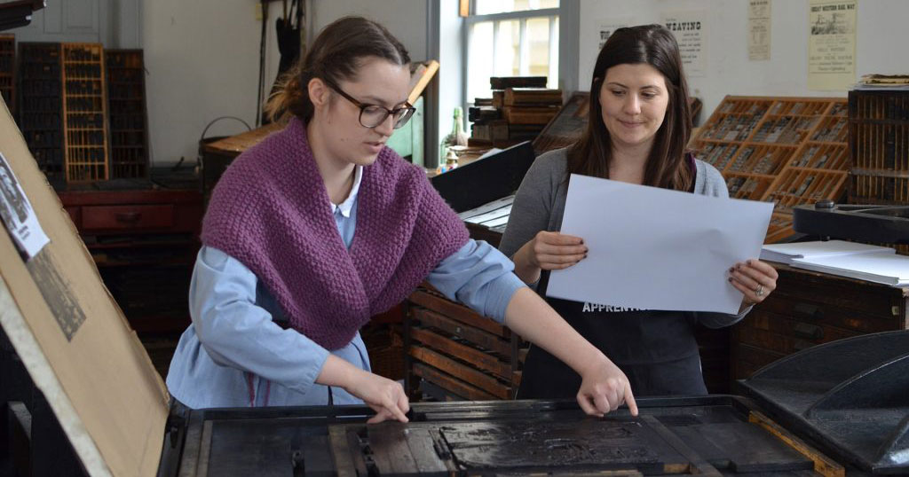 a student and instructor take part in a print making workshop at The Village at Black Creek