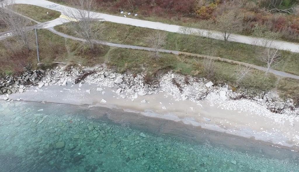 Part of the eastern shoreline with displaced material and exposed rebar along beach.