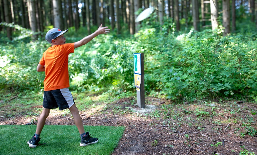 a student plays disc golf at a TRCA PA day camp at Albion Hills Field Centre